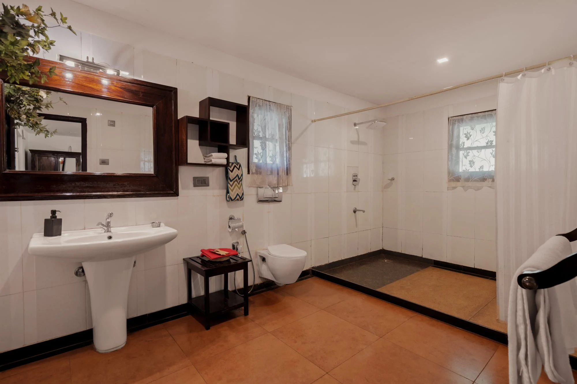 A spacious white cottage bathroom with an open shower court