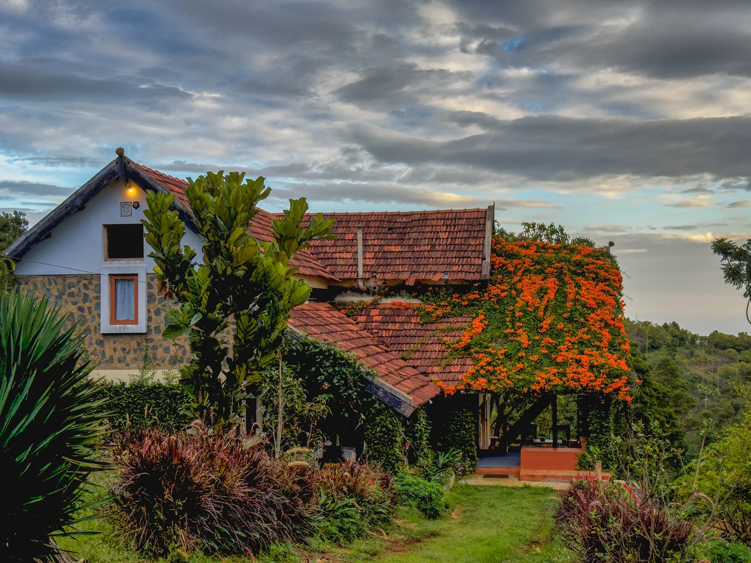 Tiled bungalow roofs bordered by flowers beneath the mountain sky