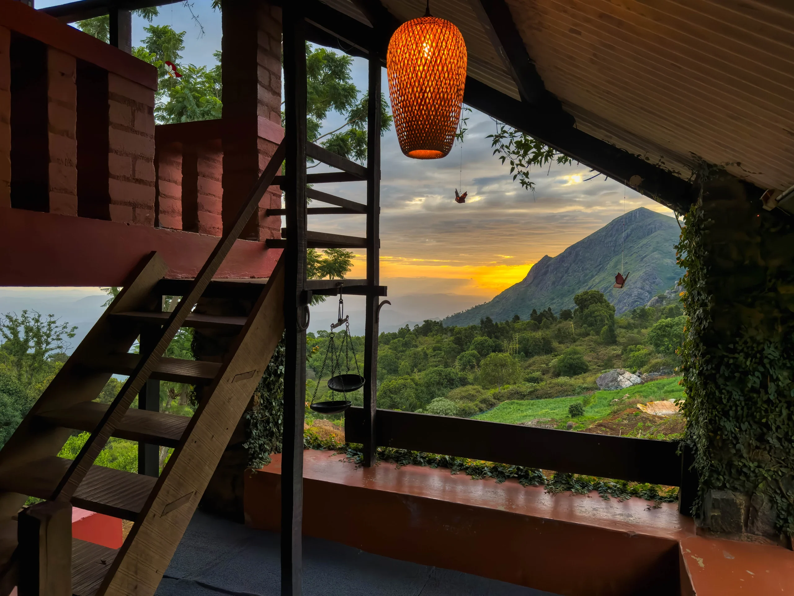A woven lantern and timber steps on the verandah overlooking the hills