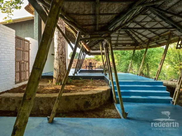 A private blue wade pool beneath a deep thatched roof