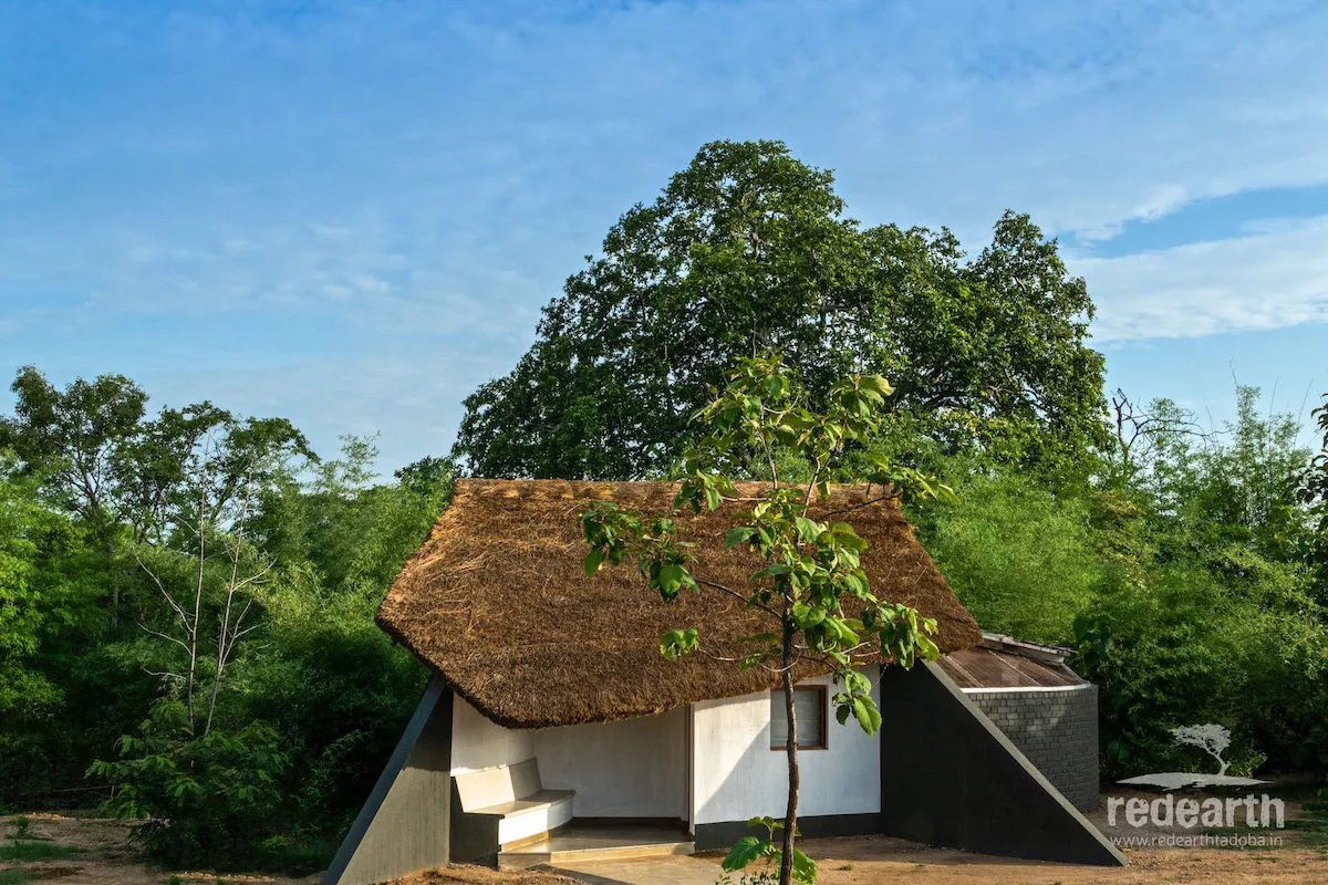 A thatched Red Earth Tadoba cottage surrounded by forest
