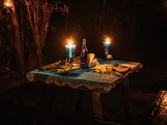 A private dinner table lit by lanterns beneath the trees
