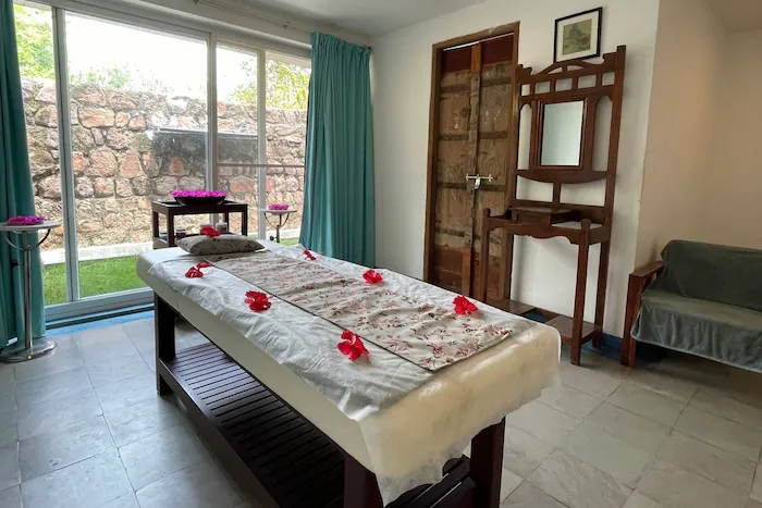 A massage bed prepared with flowers in a calm treatment room